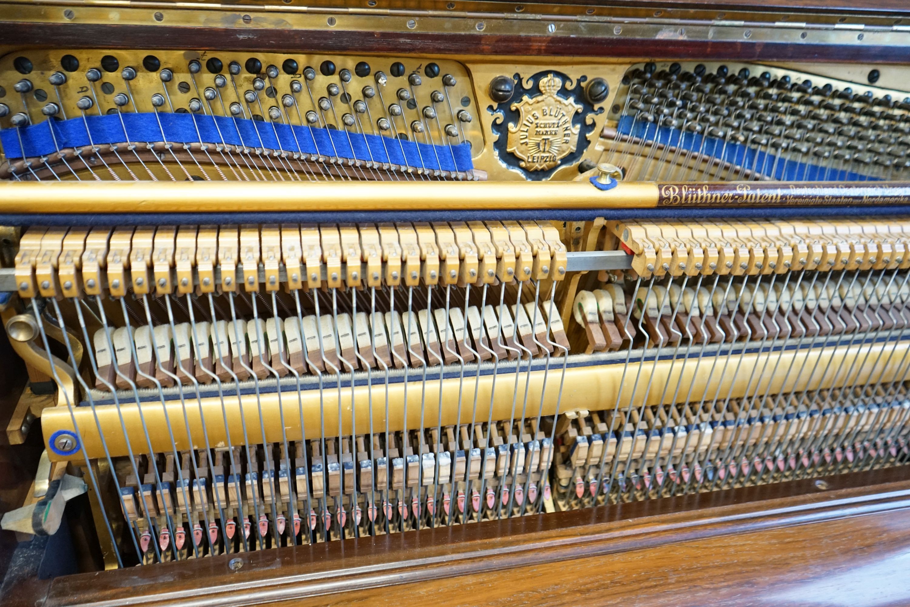 An early 20th century walnut cased Bluthner upright piano, Serial Number 92280